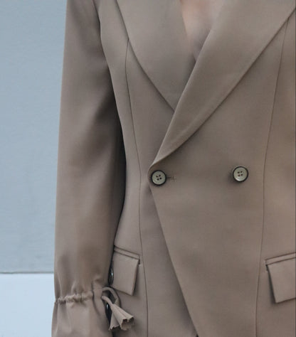 Close-up of a beige trench coat with a blurred background